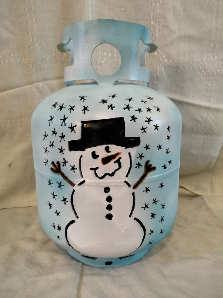 a glass jar with a snowman painted on it