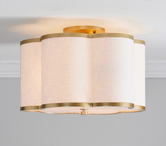 a light that is on in a room with a white wall behind it and two lamps hanging from the ceiling