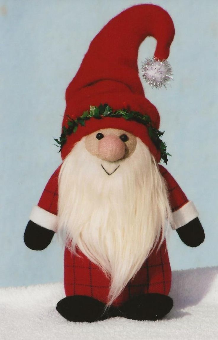 a red and white santa claus doll with long white hair