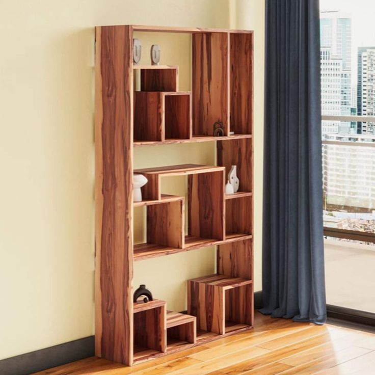 a wooden shelf with several cubes on it in front of a window overlooking a city