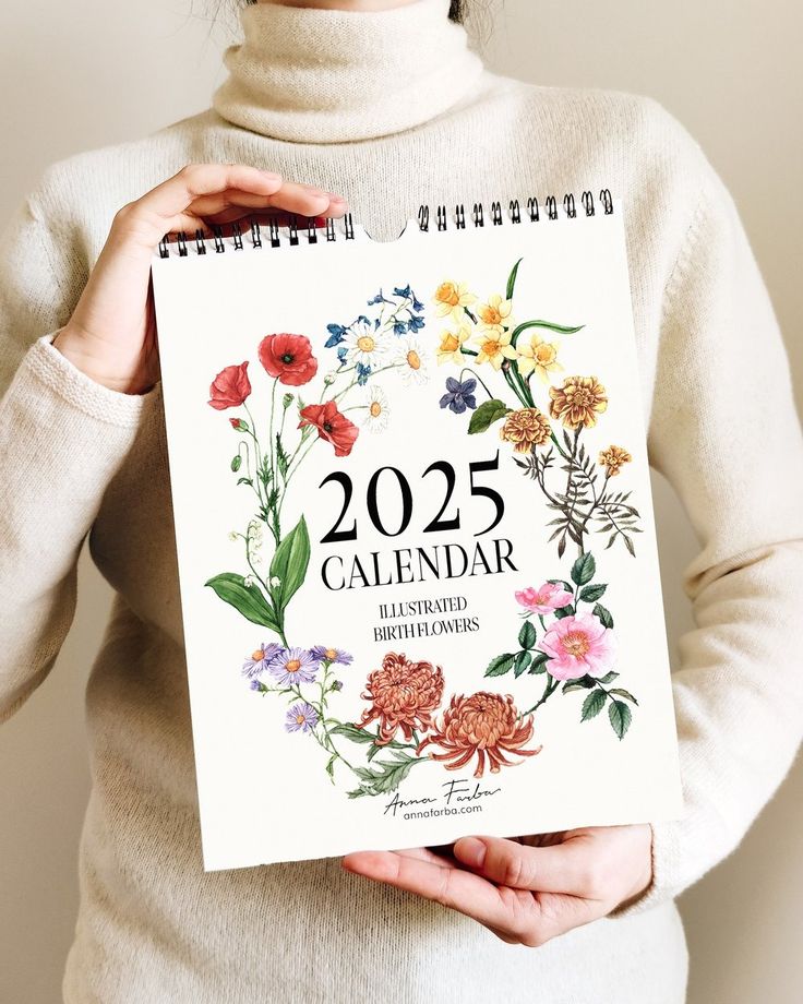 a woman holding a calendar with flowers on it