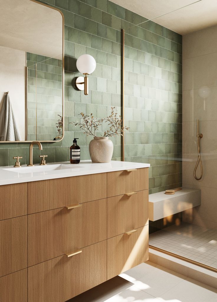 a bathroom with green tiled walls and wooden cabinetry next to a white bathtub