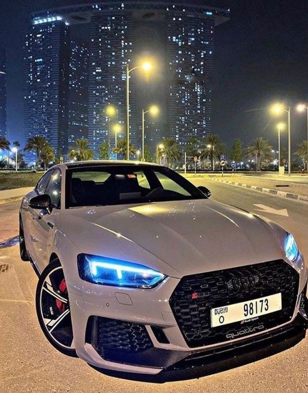 a white sports car parked on the street at night