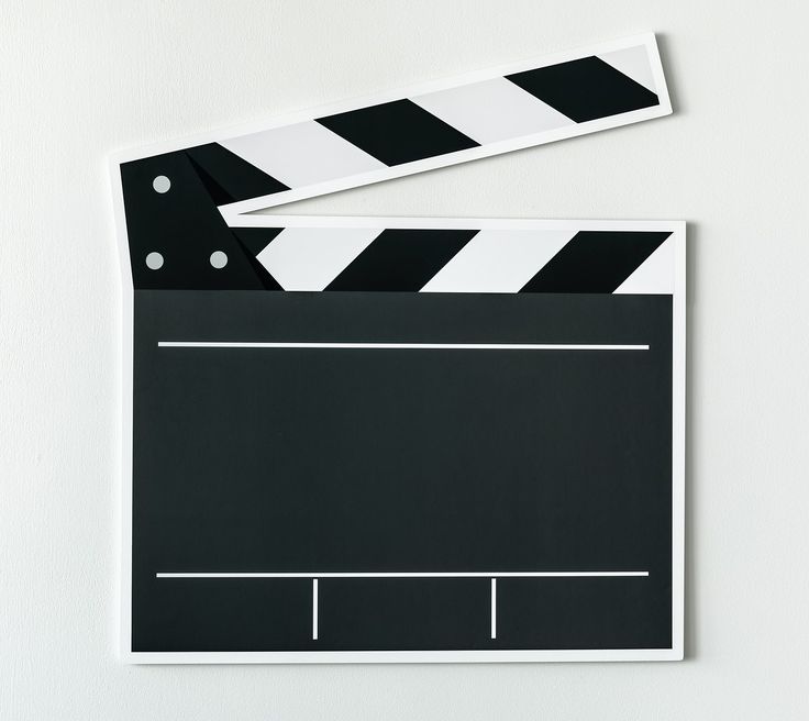 a black and white movie clapper next to a pair of scissors