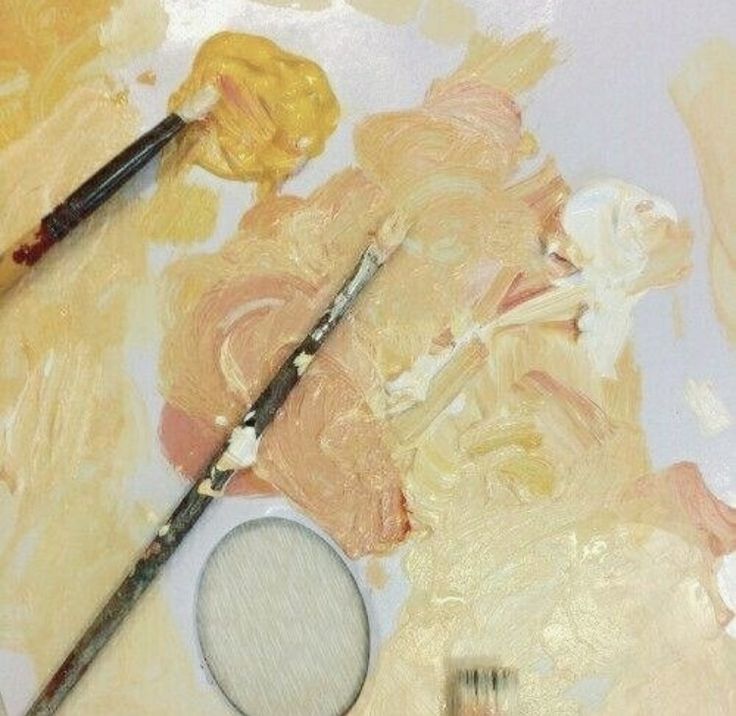 two paintbrushes sitting on top of a painting