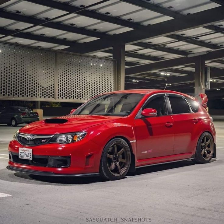 a red car parked in an empty parking garage