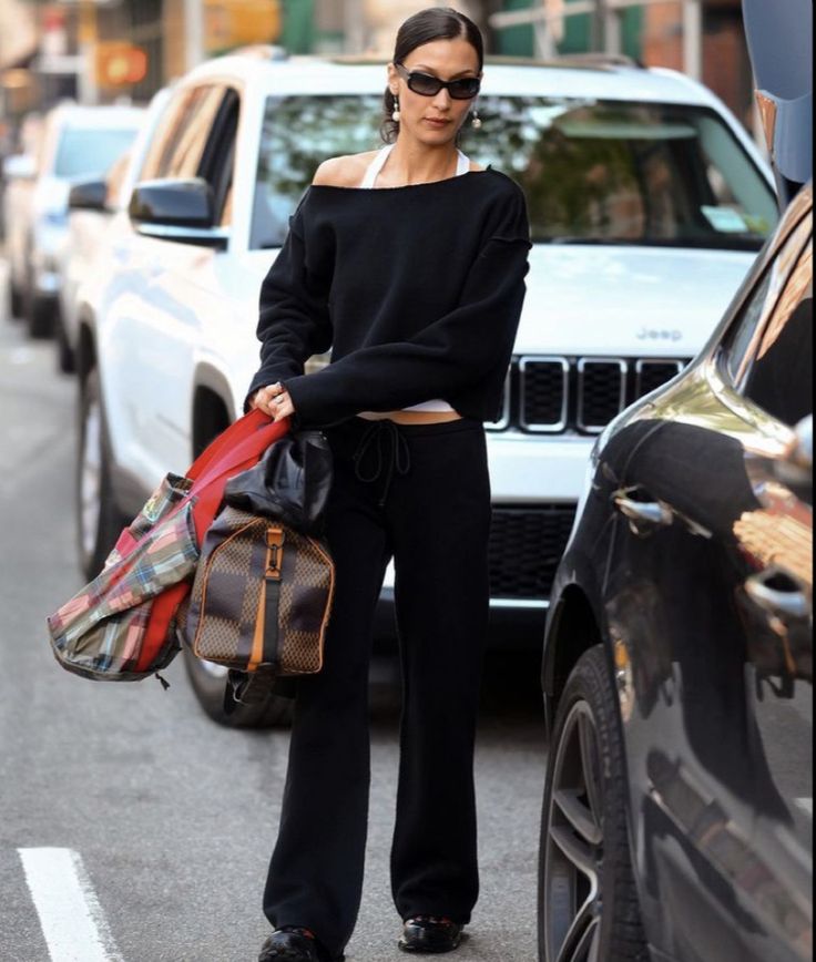 a woman is walking down the street with her purse