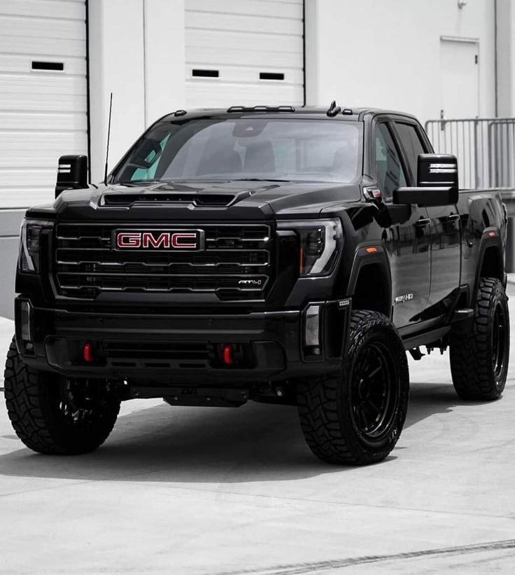 a black truck parked in front of a garage