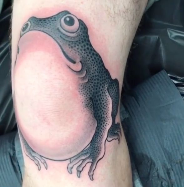 a black and white frog tattoo on the leg