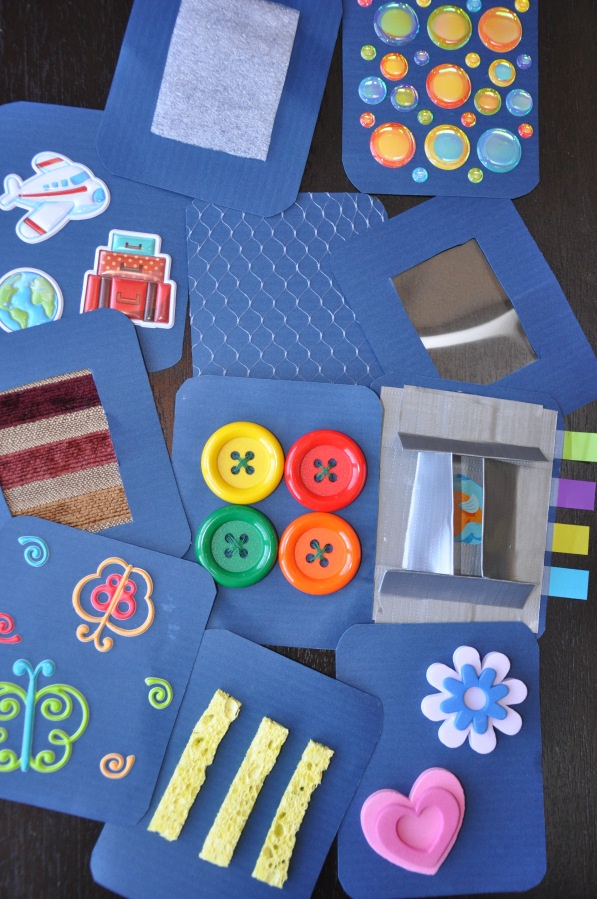 various crafting materials are laid out on a blue tablecloth with scissors and buttons