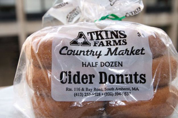 some kind of bread wrapped in plastic on top of a white tablecloth with the words, country market half dozen cider donuts