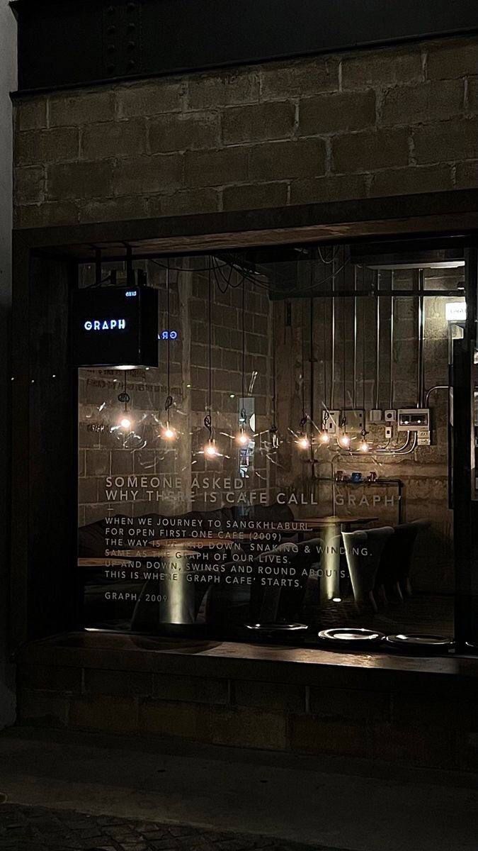 an empty restaurant window at night with the lights on