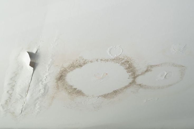 the ceiling is covered in white dust and water stains, with two circles drawn on it