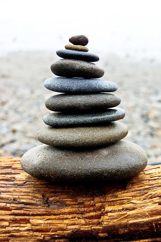 a stack of rocks sitting on top of a wooden log