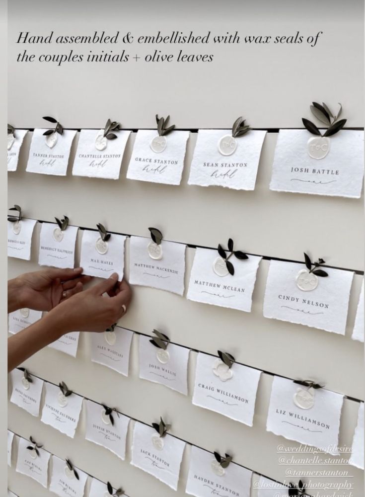 a person is placing cards on a wall with black and white tags attached to it