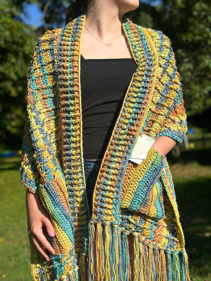 Trendy, boho inspired, multicolored pocket shawl. This fun-colorful design boasts 10 inches of flirty fringe on either end of the shawl.  Full length: 66 inches ( not including the 10 inches of fringe on either end) Width: 16 inches Care: wash in cold water on gentle cycle, lay flat or hang to dry Pocket Shawl, Pocket Scarf, Pocket Scarves, Trendy Boho, Colorful Design, Shawls And Wraps, Crochet Clothes, Scarf Accessory, Color Design