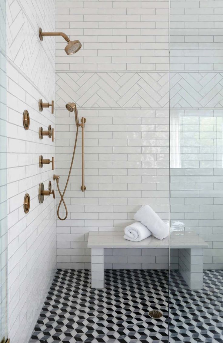 a bathroom with black and white checkered flooring, shower head, and bench