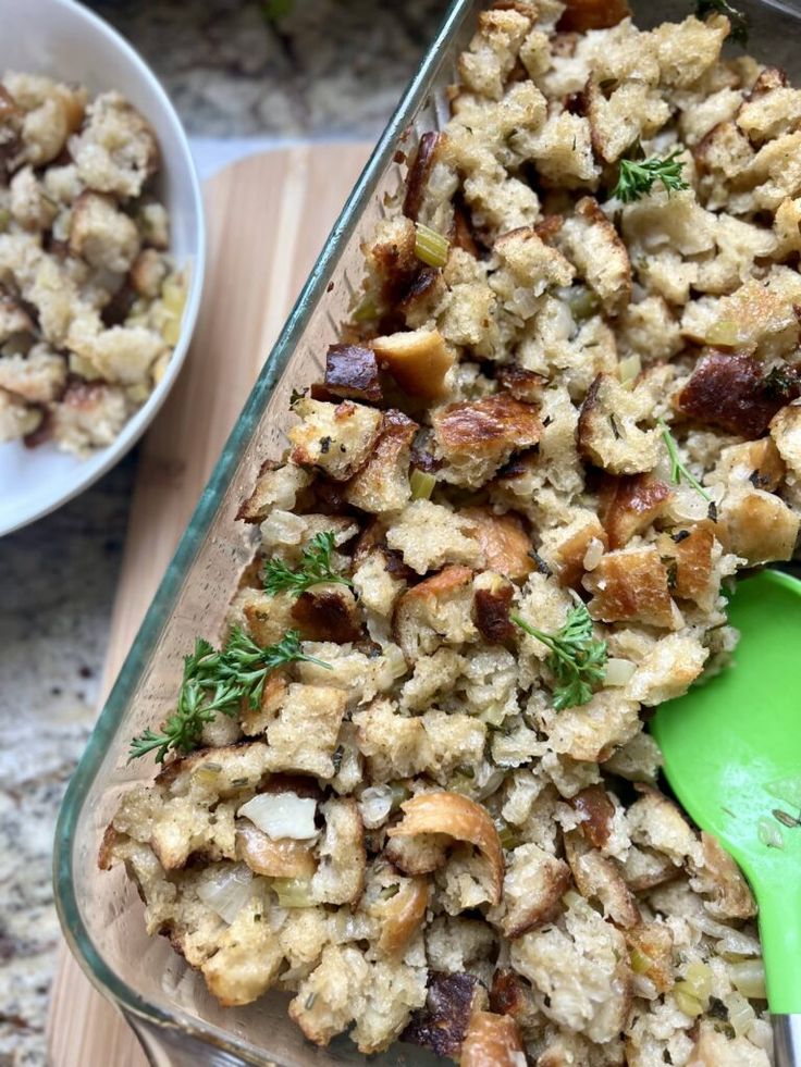 a casserole dish with stuffing in it and a green spoon next to it