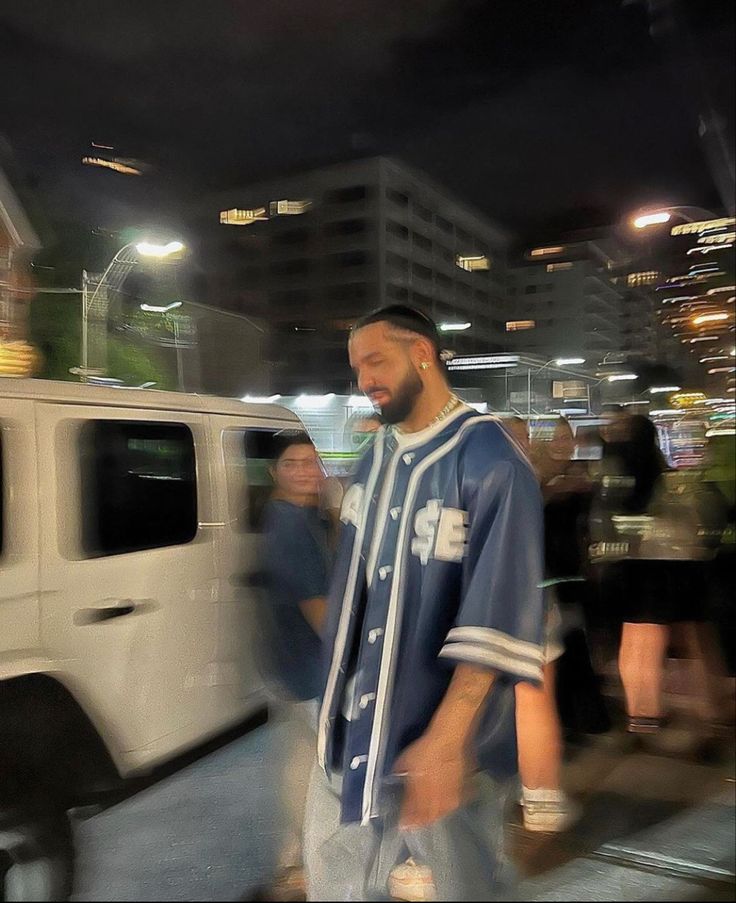 a man walking in front of a white van at night