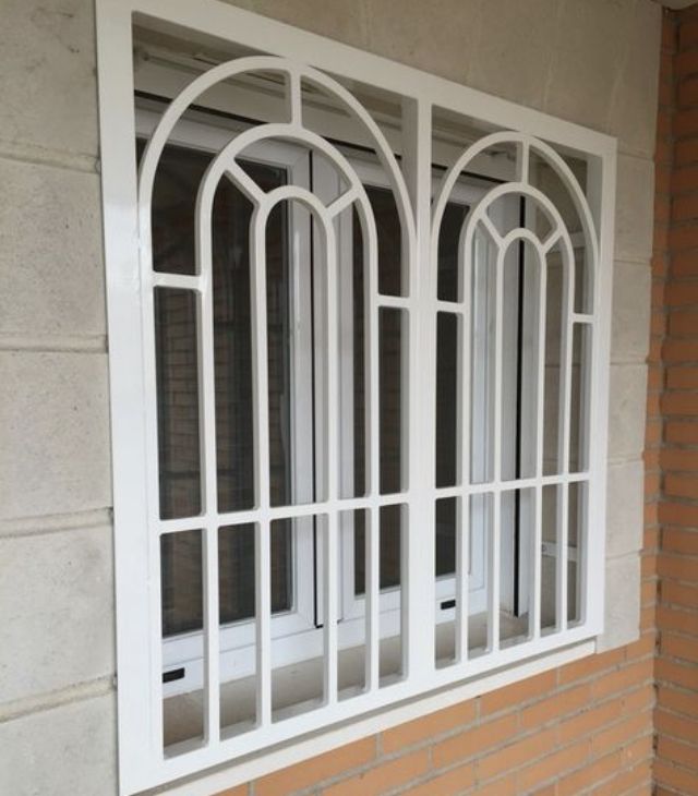 a white window on the side of a brick building