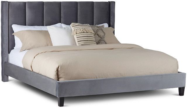 a bed with a gray headboard and pillows on top of it, against a white background