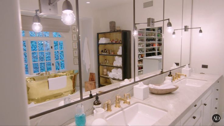 a bathroom with double sinks and large mirrors