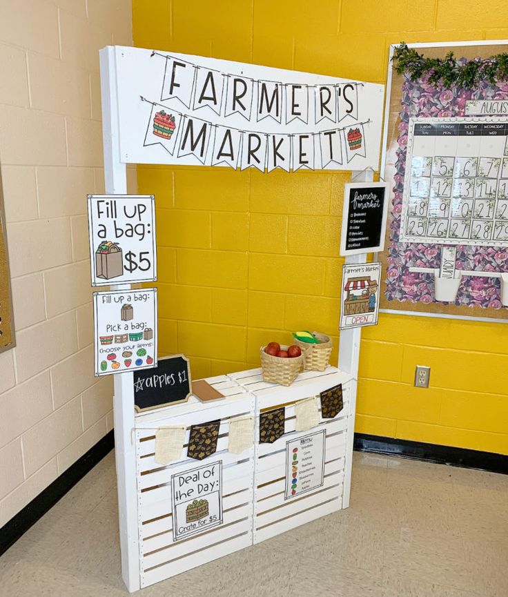 a farmers market display in the middle of a school hallway with yellow walls and white writing on it