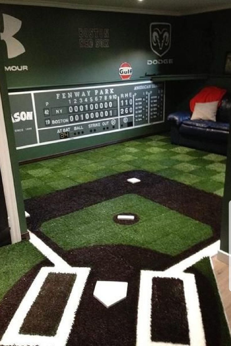 the inside of a baseball themed room with artificial grass on the floor and in the dugout