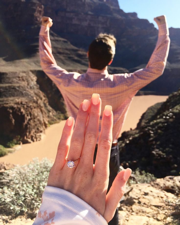 a man holding his hands up in the air while standing next to a woman's hand