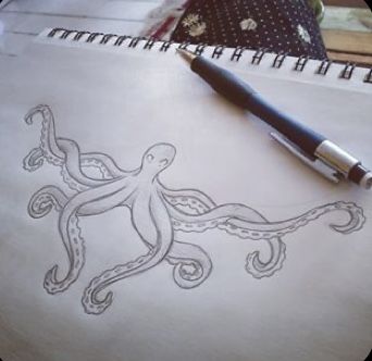 an octopus drawn on paper next to a pen