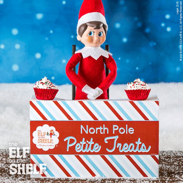 an elf is sitting behind a sign that says north pole petite treats