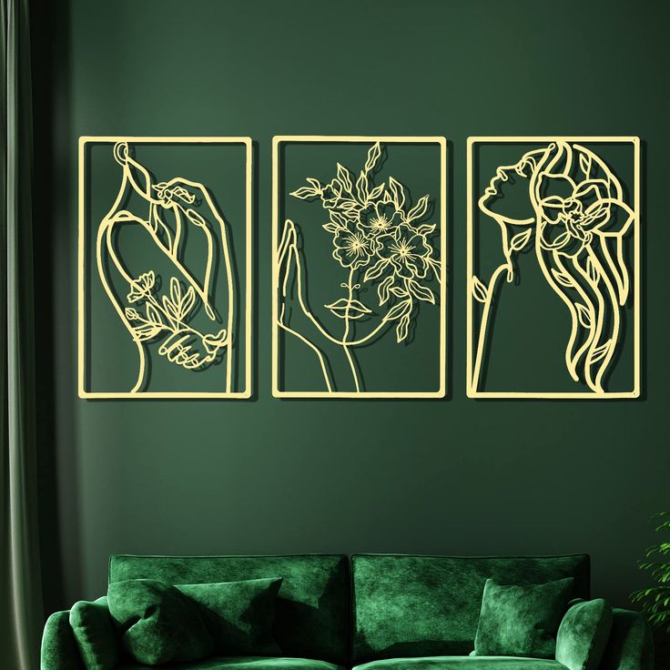 three metal wall art pieces on a green wall in a living room with couches