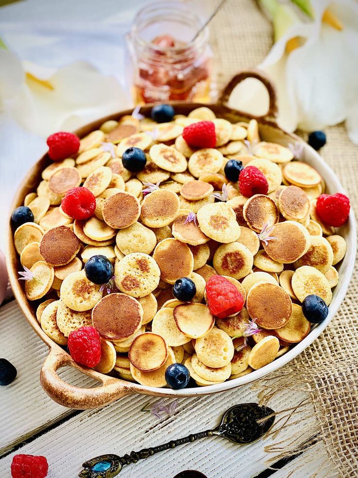 a bowl filled with bananas and raspberries on top of a table