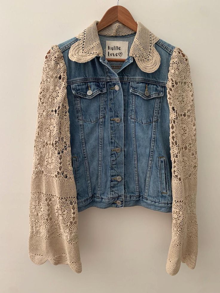 a denim jacket with crocheted sleeves hanging on a hanger