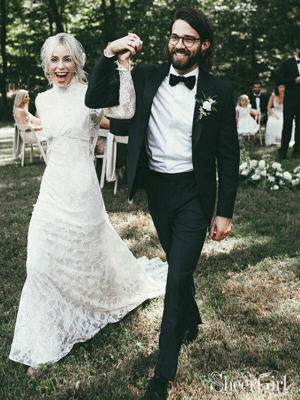 a bride and groom walking through the grass at their outdoor wedding ceremony with guests in the background