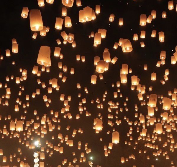 many lanterns are floating in the air at night