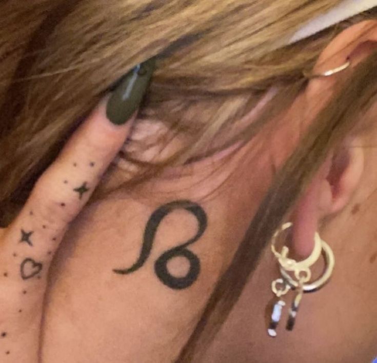 a close up of a person with a tattoo on their neck and behind her ear