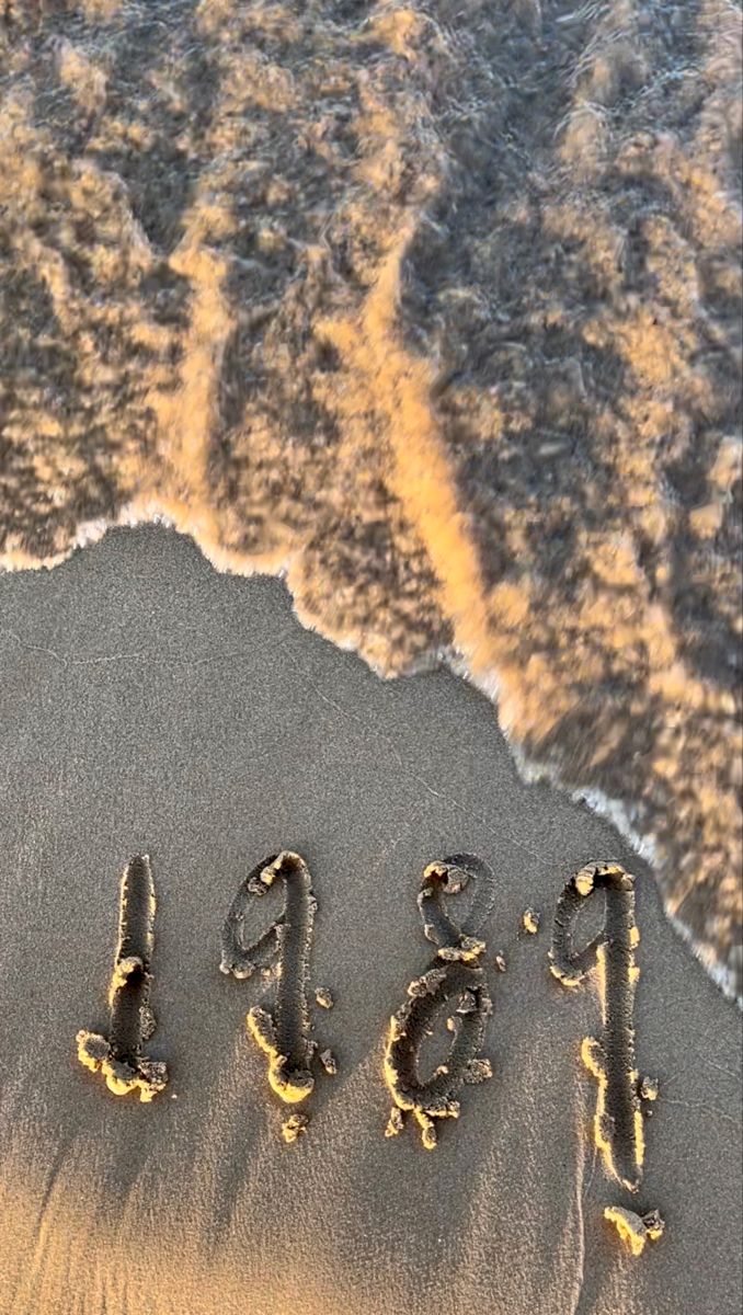 the word pisc written in sand on beach next to ocean shore with waves coming in