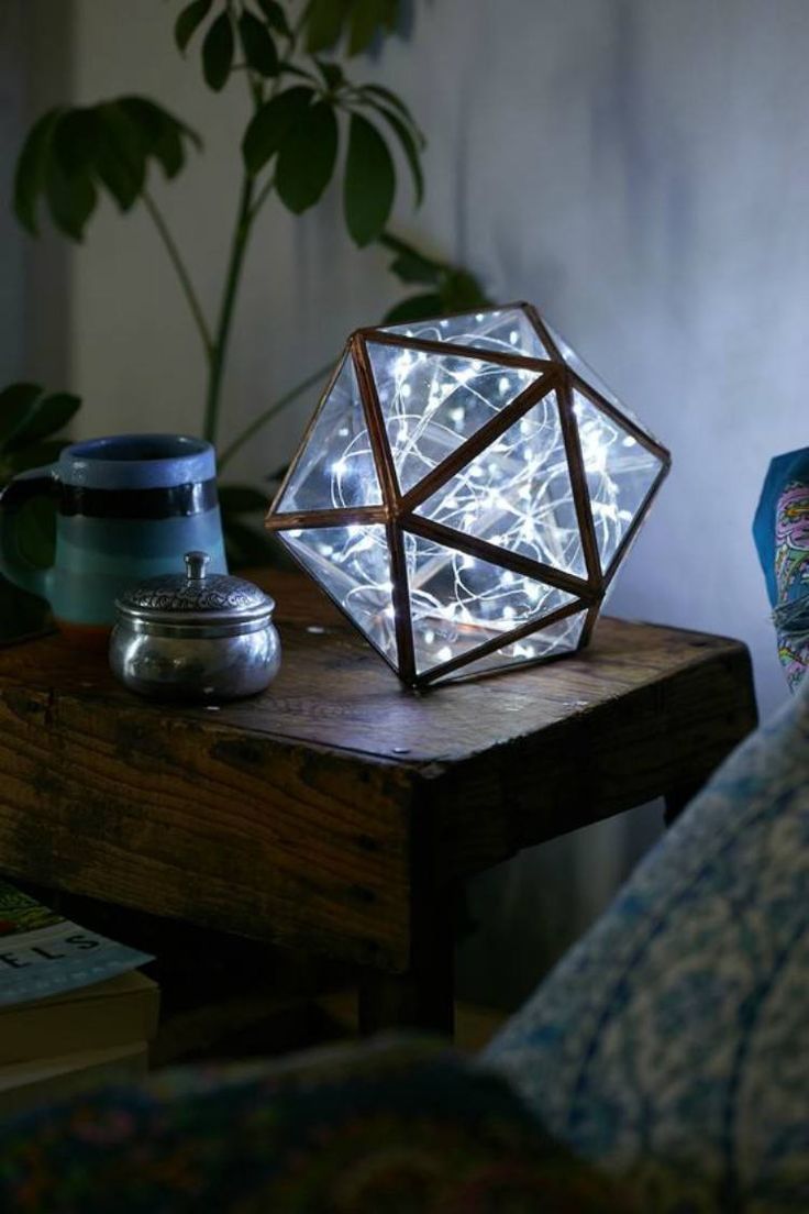 a table with a lamp on top of it next to a potted plant and other items