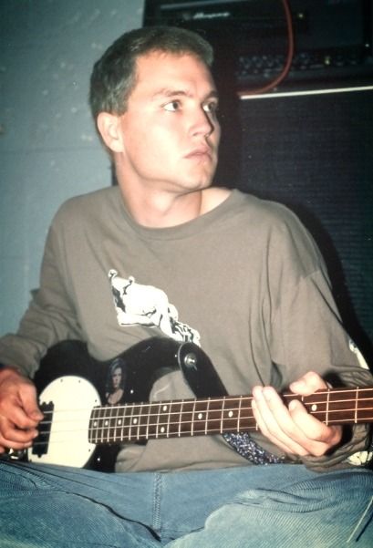 a man sitting down playing an electric guitar