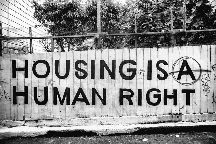 a black and white photo of a sign that says housing is a human right