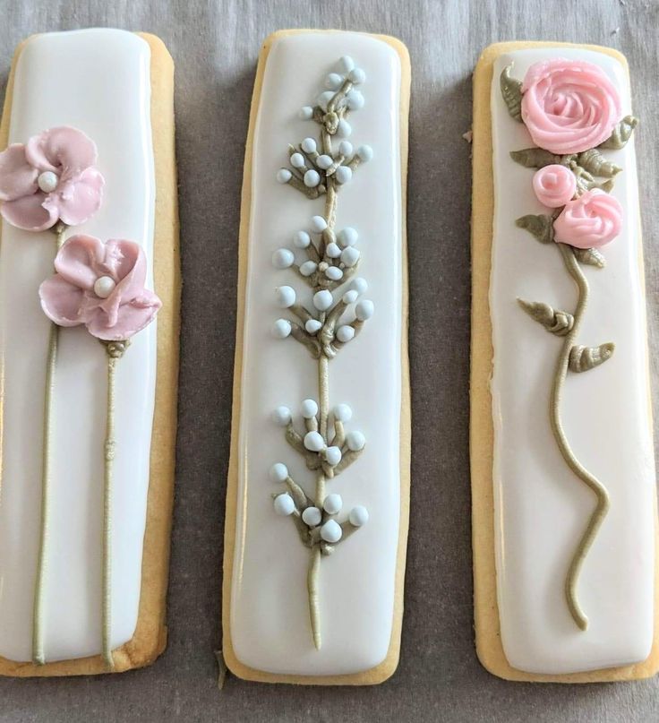 three decorated cookies sitting on top of a table next to each other in the shape of flowers