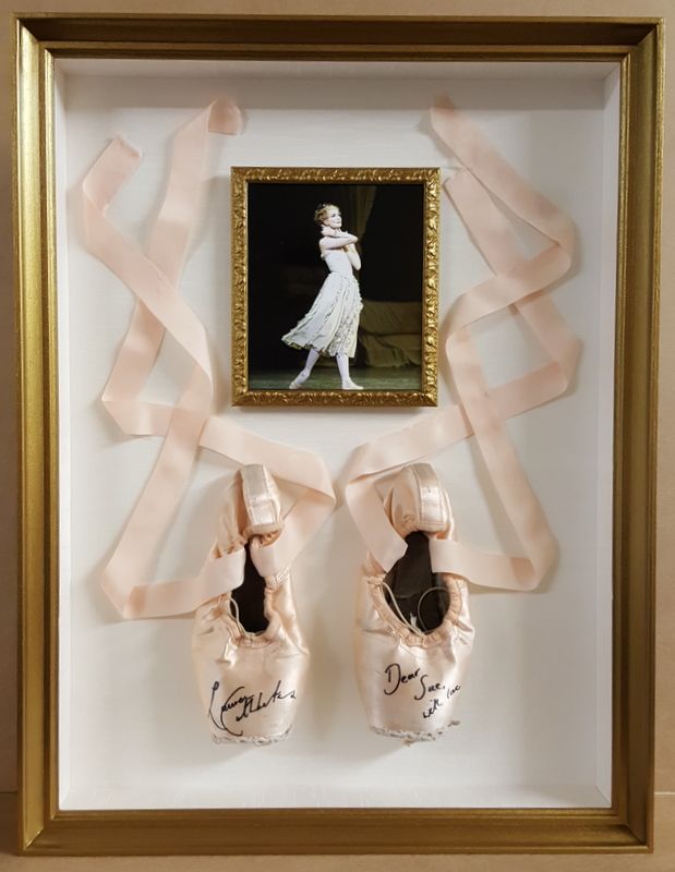 a framed photo with two pairs of ballet shoes