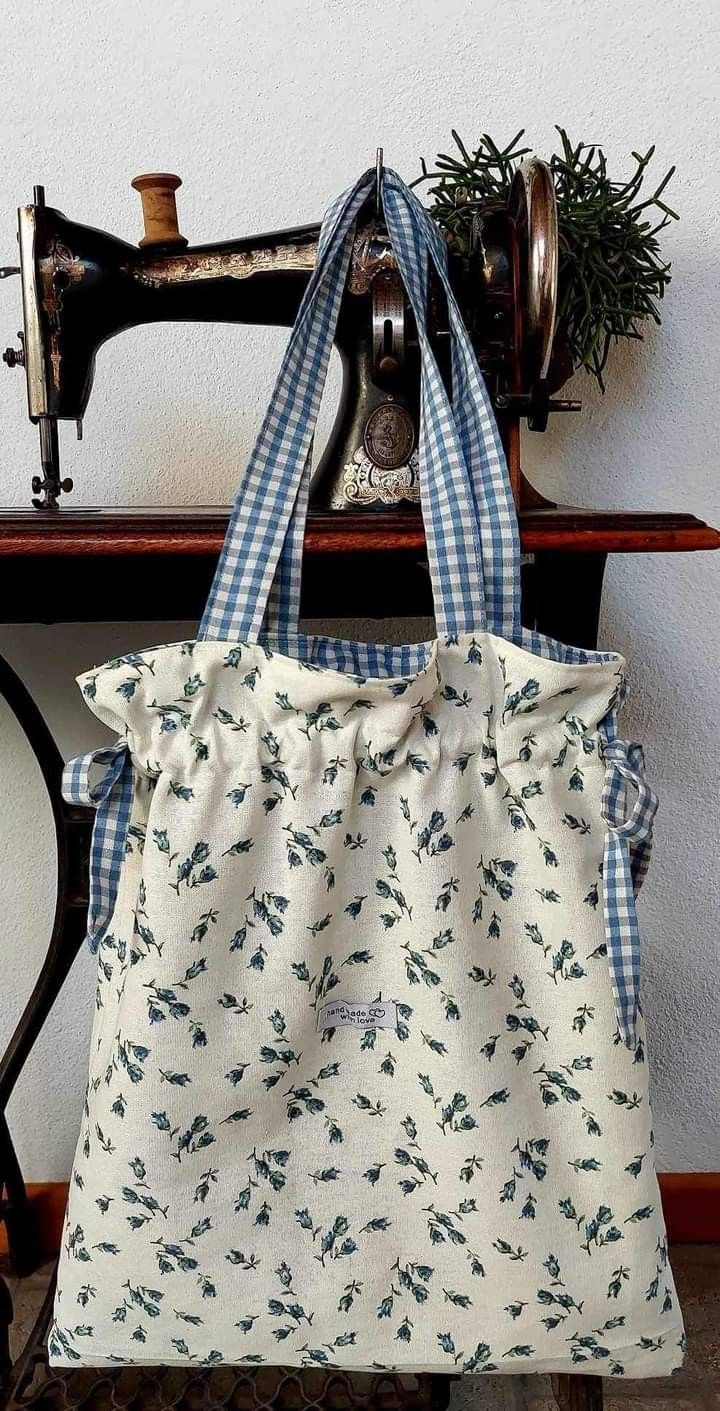 a white and blue bag sitting on top of a table next to a sewing machine