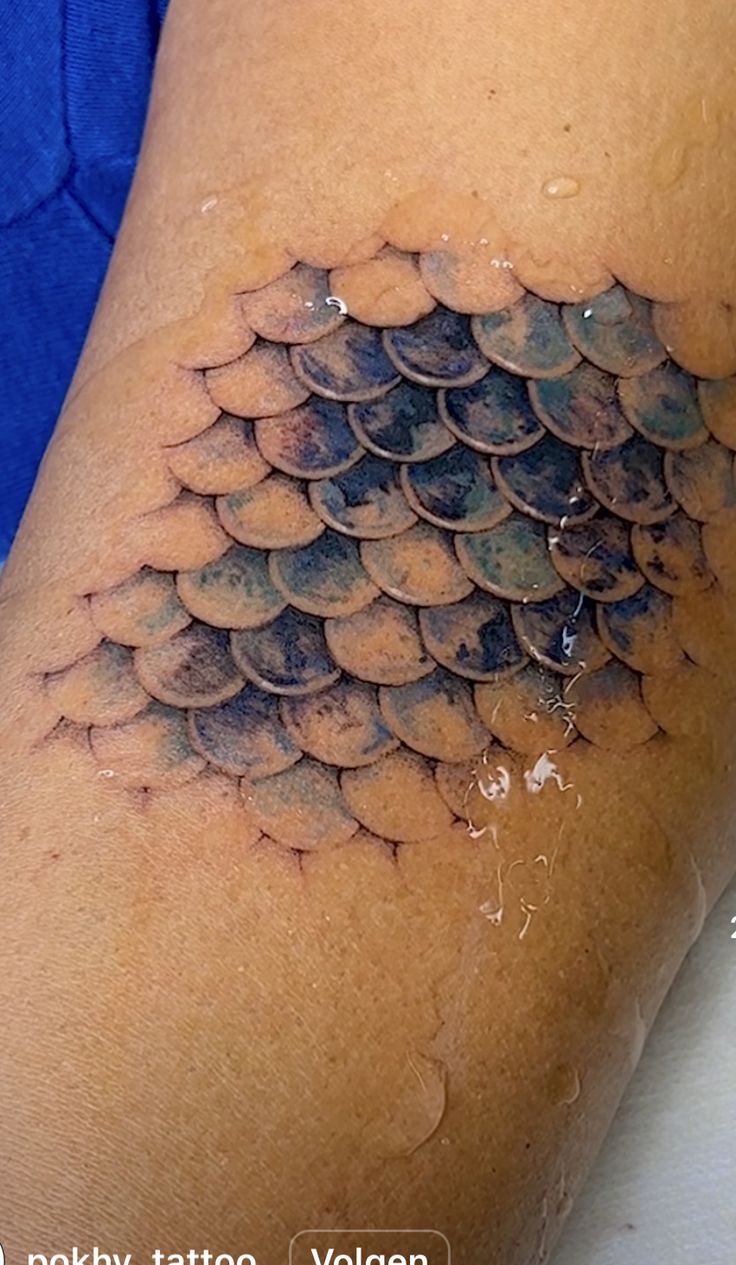 a woman with a tattoo on her thigh that looks like a fish's tail