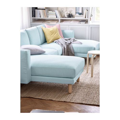 a living room with a blue sectional couch and coffee table in front of the window