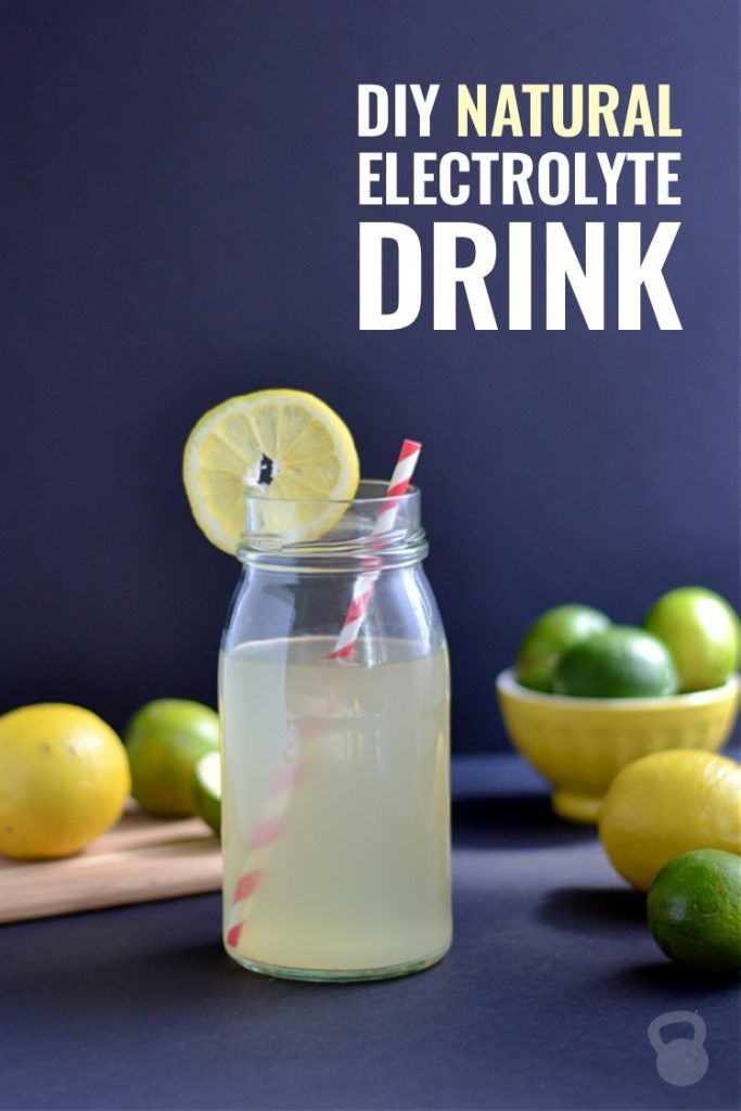 a mason jar filled with lemonade next to limes