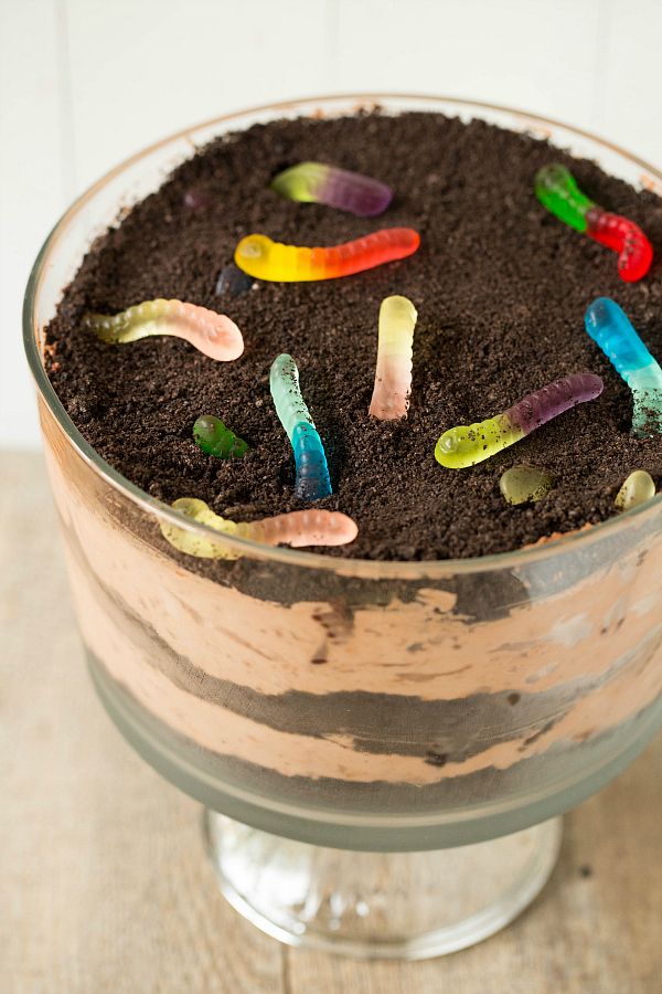 a glass bowl filled with dirt and gummy worms