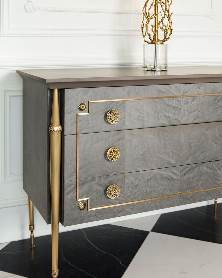 a grey and gold chest of drawers in a room