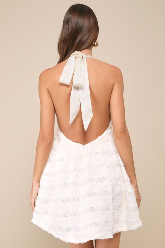 Everyone will be asking about the chic babe in the Lulus Easily Poised Ivory Textured Halter Mini Dress! This stunning dress boasts a woven construction with a pierced design and an allover mesh appliques. Tying halter neckline tops a bodice with a plunging V at the front and a set-in waist. Flaring skirt finishes at a mini hem. Tulle layer for volume. Hidden zipper/clasp at back. Fit: This garment fits true to size. Length: Mid-thigh. Size medium measures 33.75" from top to bottom. Bust: Great Feminine Mini Dress With Back Zipper For Party, Summer Party Mini Dress With Back Opening, White Mini Dress With Back Zipper, Glamorous Wedding Dress With Back Zipper, Summer A-line Mini Dress With Back Opening, Spring A-line Dress With Back Opening, Feminine Mini Dress With Back Zipper For Date Night, Summer Wedding Halter A-line Dress, Wedding Mini Dress With Back Zipper